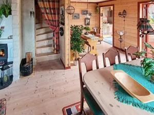 a room with a table and chairs with a surfboard on it at Four-Bedroom Holiday home in Hundeidvik in Hundeidvik