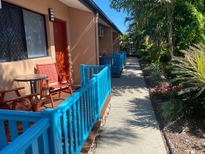 une balustrade bleue sur une terrasse couverte avec des chaises et une table dans l'établissement Bluewater Harbour Motel, à Bowen