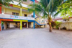 un edificio con una palmera delante en De Real Macaw, en Caye Caulker