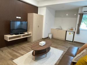 a living room with a television and a coffee table at Pimann Place Hotel in Chiang Rai