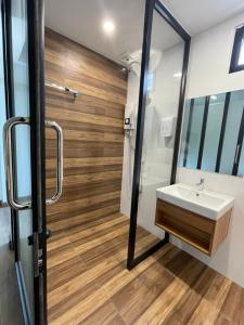 een badkamer met een wastafel en een spiegel bij Pimann Place Hotel in Chiang Rai