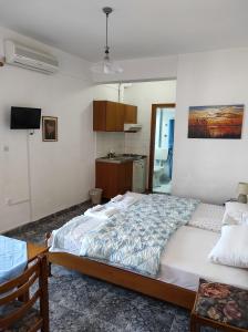 a bedroom with a large bed and a kitchen at Peristerianos apartments in Nea Skioni