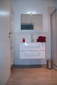 bagno con lavandino bianco e specchio di Premium Ferienwohnung Südsonne a Witzenhausen