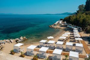 an aerial view of a beach with umbrellas and the water at Angsana Corfu Resort & Spa in Benitses