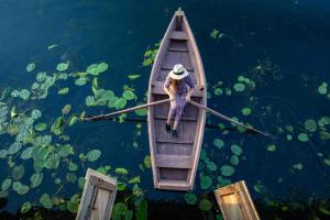 a man is rowing a boat in the water at Mr.Banga in Alūksne