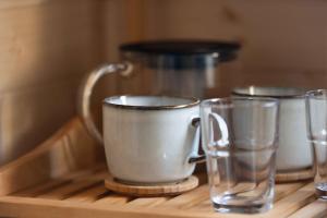 a tray with two cups and two glasses on it at Mr.Banga in Alūksne