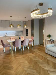 a living room with a table and chairs and a couch at Eternity Luxury Apartment Dolny Sopot in Sopot