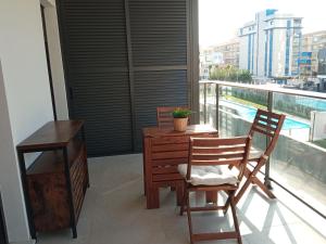 ガンディアにあるPlaya Gandía Residencial Álamoのテーブルと椅子2脚、バルコニーが備わる客室です。