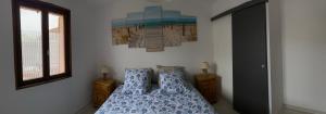 a bedroom with a bed and a painting on the wall at Gîte des Lianne, Pays des 7 vallées très proche de la côte d'Opale in Beaurainville