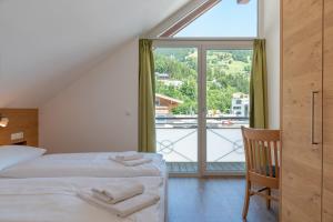 sypialnia z łóżkiem i dużym oknem w obiekcie Fourteen Zell am See S&P by All in One Apartments w mieście Zell am See