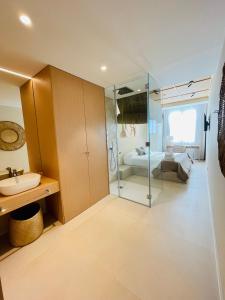 a bathroom with a glass shower and a sink at Hotel Boutique Sabbia Valencia in Valencia