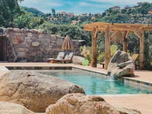 een zwembad met een prieel en enkele rotsen bij Résidence de Luxe 4 étoiles à Pietralba, 4 logements piscine chauffée BALAGNE in Pietralba