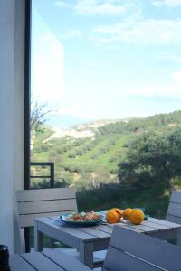 a table with a plate of food and oranges on it at Agriturismo Casebianche in Montallegro