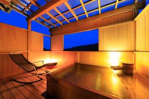 a sauna with a chair and a window at night at Yugawara Fuga in Yugawara