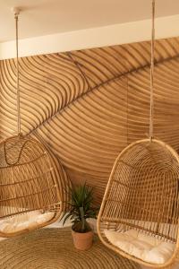 two hanging rattan chairs in a room with a plant at Hotel Boutique Sabbia Valencia in Valencia