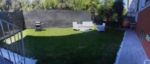 a backyard with a table and chairs on the grass at Black&White guest house in Iglesias