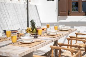 a table with food and orange juice on it at Lindian Plumeria in Lindos