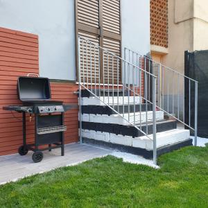 a grill sitting next to a building with stairs at Black&White guest house in Iglesias