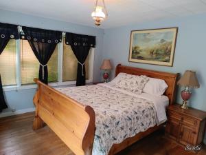 ein Schlafzimmer mit einem Bett und zwei Fenstern in der Unterkunft Chilliwack Accomodation in Chilliwack