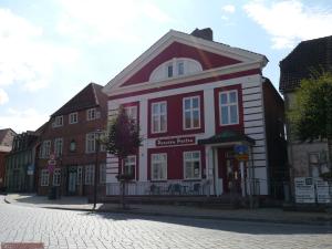 a red and white building on a city street at Pension Paetau in Schönberg