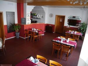 Un comedor con mesas y sillas en un restaurante. en Pension Paetau, en Schönberg