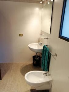 Baño blanco con lavabo y aseo en Camera con Bagno, en Castel San Pietro Terme