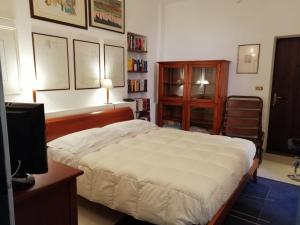 1 dormitorio con 1 cama, escritorio y TV en Camera con Bagno, en Castel San Pietro Terme