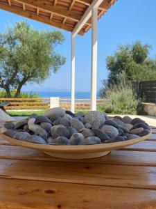 a bowl filled with rocks on a wooden table at Joyas cosy apartment in Tragaki