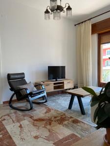 uma sala de estar com uma cadeira e uma televisão em Ciccio apartment em Bovalino Marina