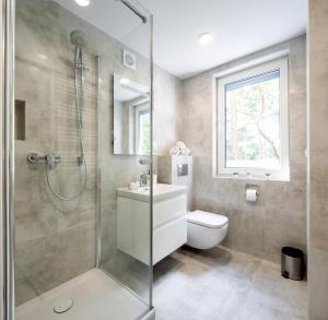 a bathroom with a shower and a toilet and a sink at Apartamenty 7 Fal in Pobierowo +30 photos