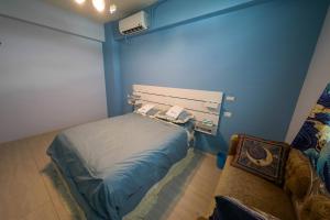 a blue room with a bed and a couch at 墾丁藍洞青旅 Blue Hole Backpacker Inn in Hengchun