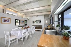 a kitchen and dining room with a table and chairs at Villa Rouge in Bet H̱ananya