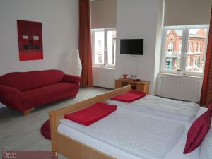 Un dormitorio con una cama y un sofá rojo. en Pension Paetau, en Schönberg