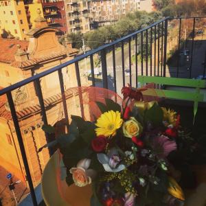 a vase of flowers sitting on a table on a balcony at Stayinbologna 3 in Bologna