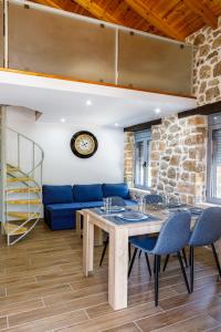 sala de estar con mesa de madera y sillas azules en ADRIAN'S LUXURY APARTMENTS 2 en Drepano