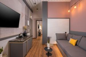 a living room with a couch and a flat screen tv at Veneri Boutique Suites in Chania