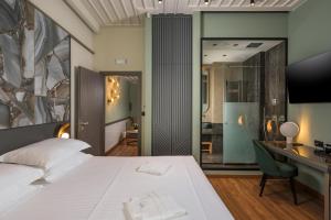 a bedroom with a white bed and a desk and a room at Veneri Boutique Suites in Chania