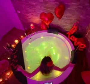 a woman in a bubble bath in a room with balloons at Suite & Relax in Conversano
