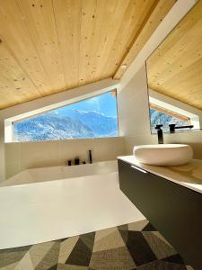 a bathroom with a sink and a large window at Chalet nature et design in Servoz