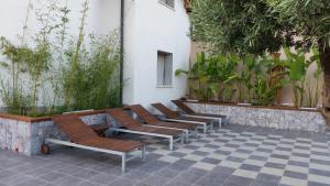 a row of chairs sitting next to a wall with plants at Villa Antheus in Graniti