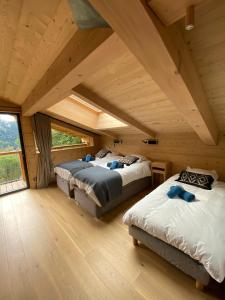 a bedroom with two beds in a wooden house at Chalet nature et design in Servoz