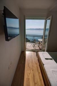 a room with a bed and a balcony with a television at Mima in Sveti Juraj
