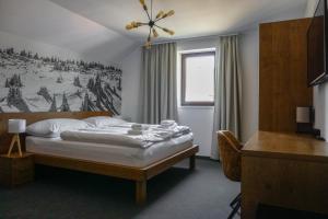 sypialnia z łóżkiem z obrazem na ścianie w obiekcie Apartmány GOLF&SKI w mieście Valča