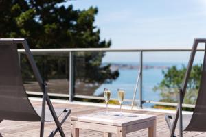 zwei Gläser Wein auf einem Tisch auf einem Deck in der Unterkunft Hôtel Les Costans, The Originals Relais in Perros-Guirec