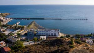 an aerial view of a building on a hill next to the ocean at Tylos Beach Hotel in Kato Pyrgos