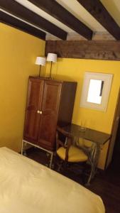 a bedroom with a bed and a desk and a chair at Posada Reserva Verde in Bárcena Mayor
