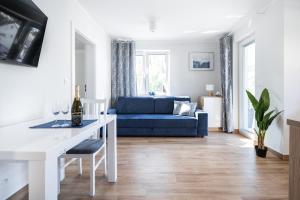 uma sala de estar com um sofá azul e uma mesa em Apartamenty 7 Fal em Pobierowo