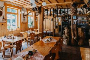 a restaurant with wooden tables and wooden chairs at Penzion Sindlovec in Oravice