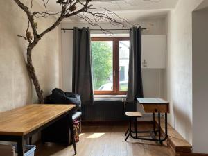 sala de estar con mesa y ventana en Gîte La Semois en Chiny