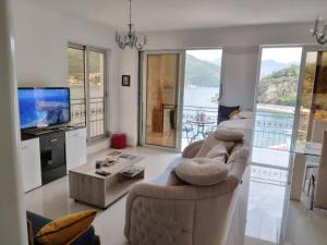 a living room with two couches and a tv at Apartment Galina in Tivat